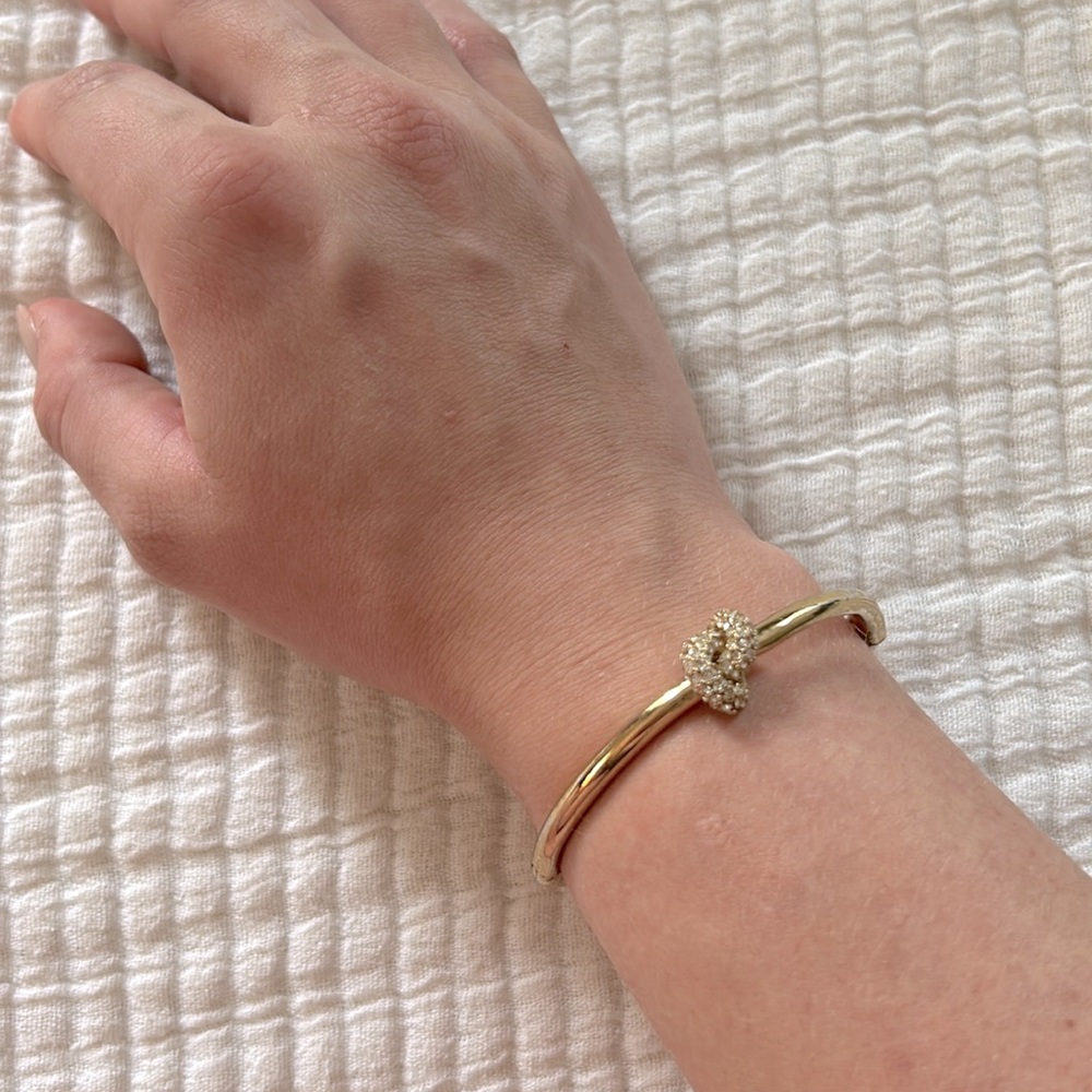 Gold Kate Spade bracelet with rhinestone knot design